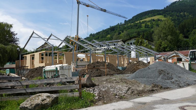 Bau des neuen Tierschutzhauses im Pinzgau mit Baustellenmaterial und Kräne.